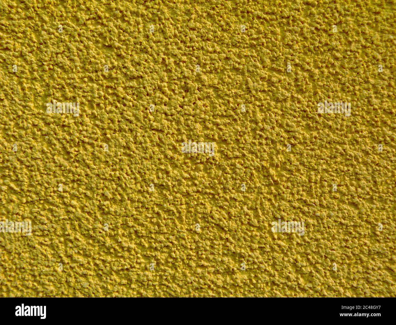texture de stuc ocre jaune sur le mur extérieur avec grains fins. papier de verre comme une surface rugueuse sablonneuse. vue rapprochée. motifs et textures concept Banque D'Images