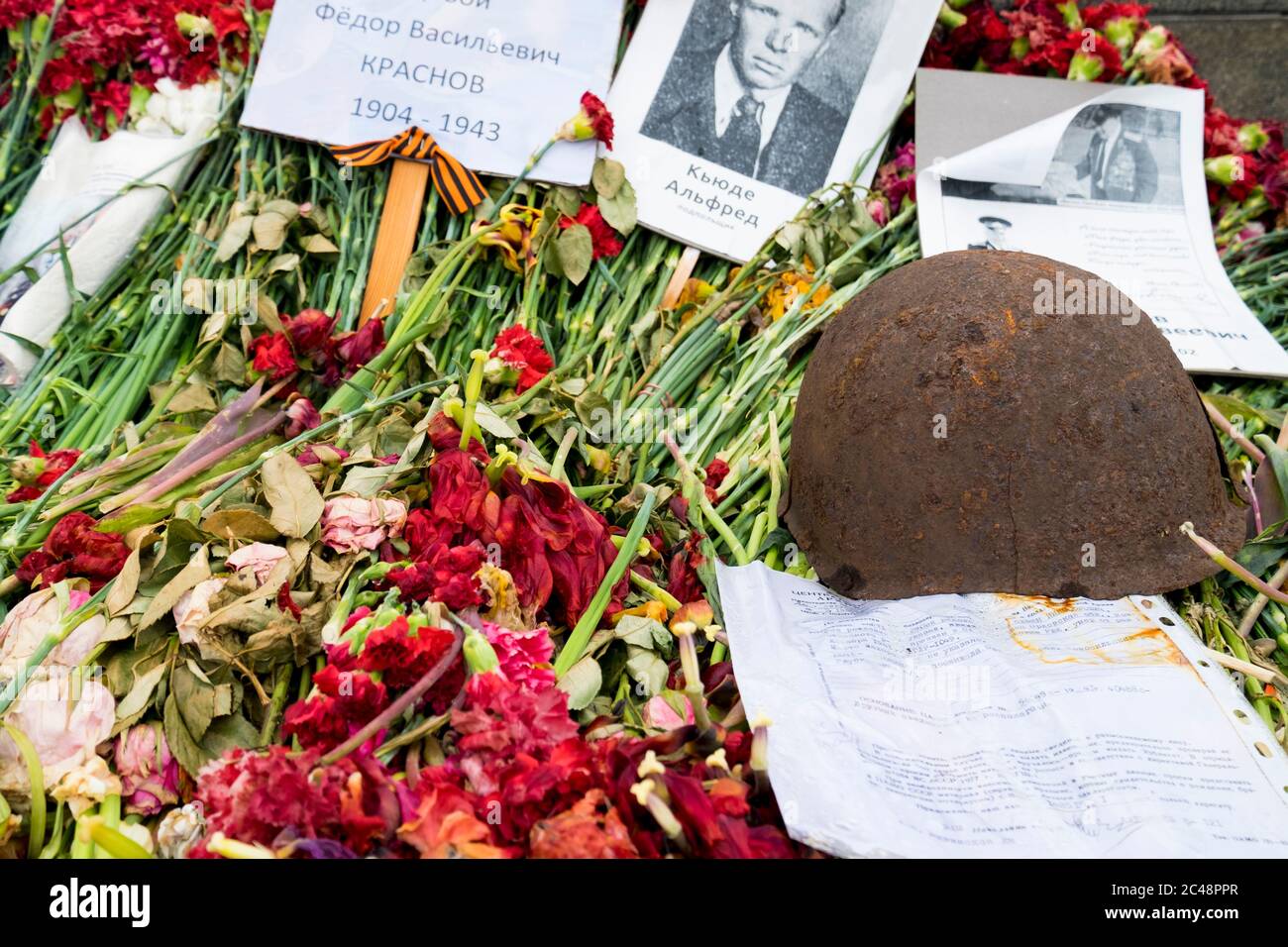 Fleurs, casque d'armée et souvenirs posés devant le monument du jour de la victoire, le 9 mai. Au Grand Mémorial de la guerre patriotique à Riga, en Lettonie. Banque D'Images