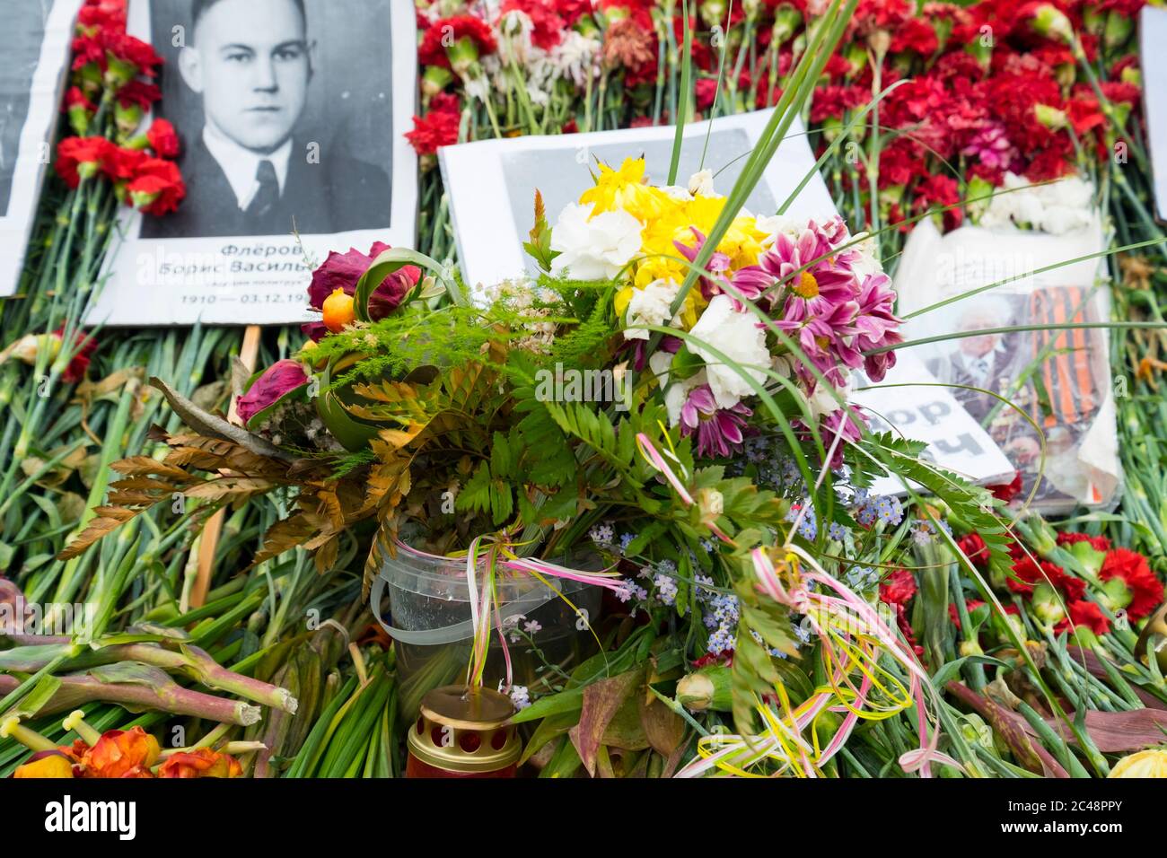 Fleurs et photographies des morts déposées devant le monument du jour de la victoire, mai 9. Au Grand Mémorial de la guerre patriotique à Riga, en Lettonie. Banque D'Images