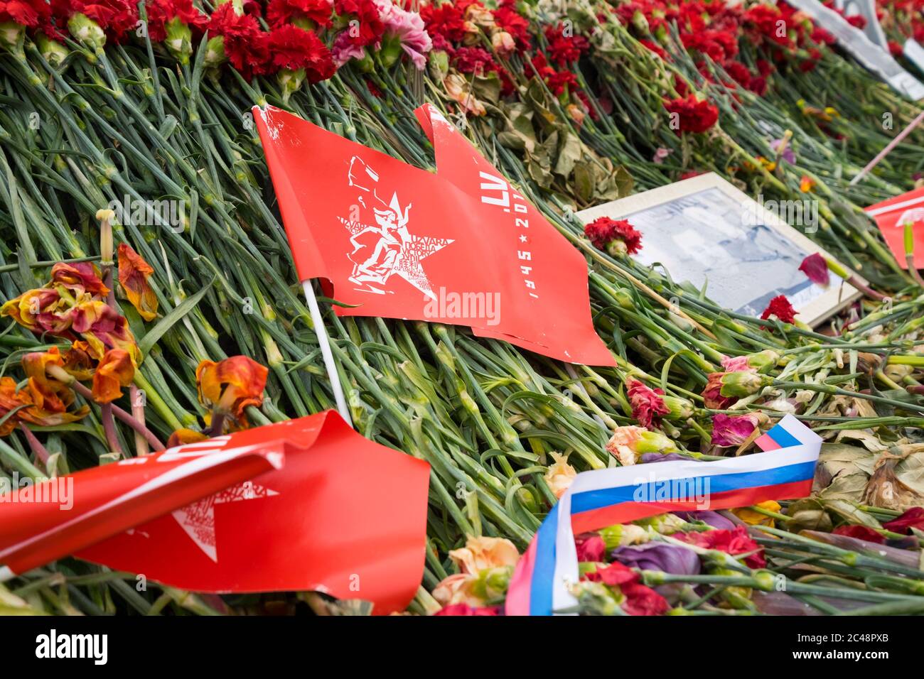 Fleurs et drapeaux posés devant le monument du jour de la victoire, le 9 mai. Au Grand Mémorial de la guerre patriotique à Riga, en Lettonie. Banque D'Images