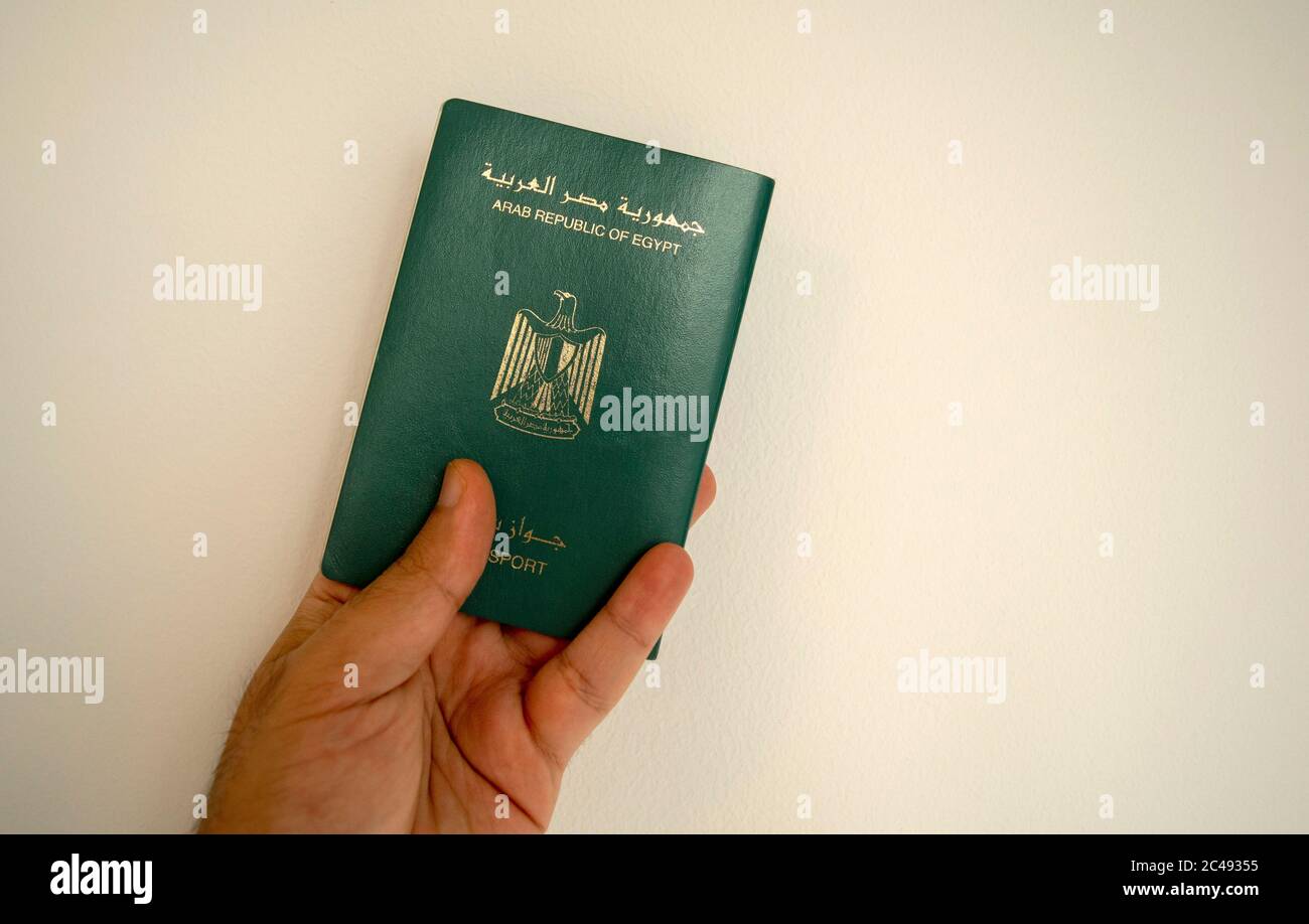 Passeport égyptien dans la main masculine. Man Hand tient le passeport international égyptien sur fond blanc clair avec un espace de copie. Banque D'Images