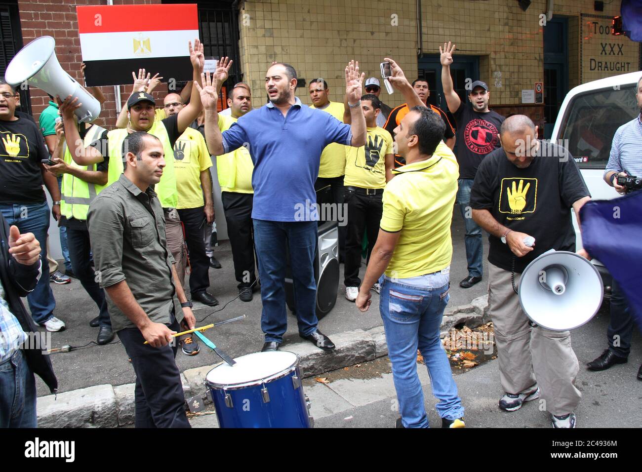 Un homme joue le tambour et des manifestants chantent devant le consulat général égyptien lors de la manifestation en faveur des Frères musulmans. Banque D'Images