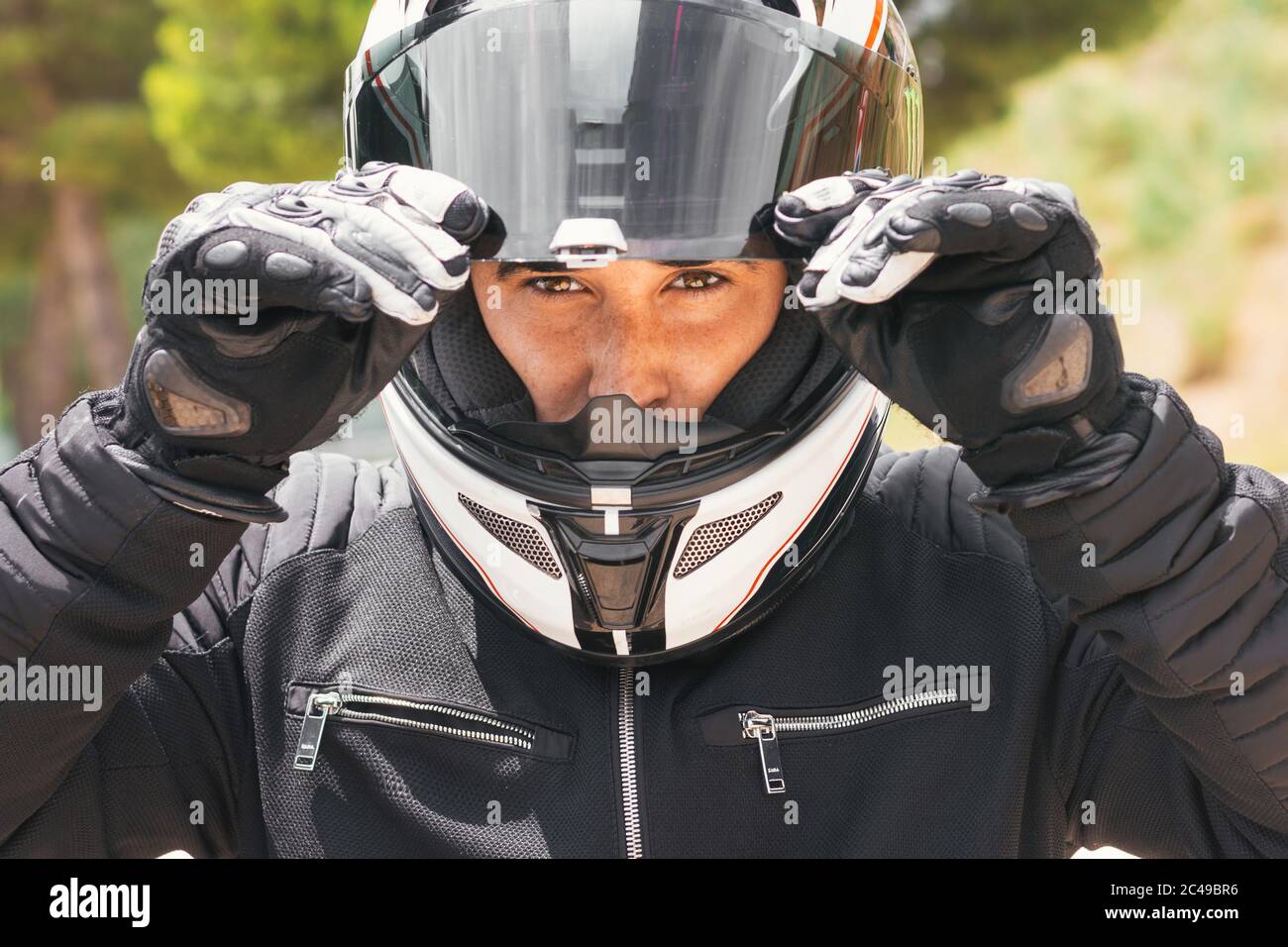 portrait rapproché d'un motard tenant son casque Banque D'Images