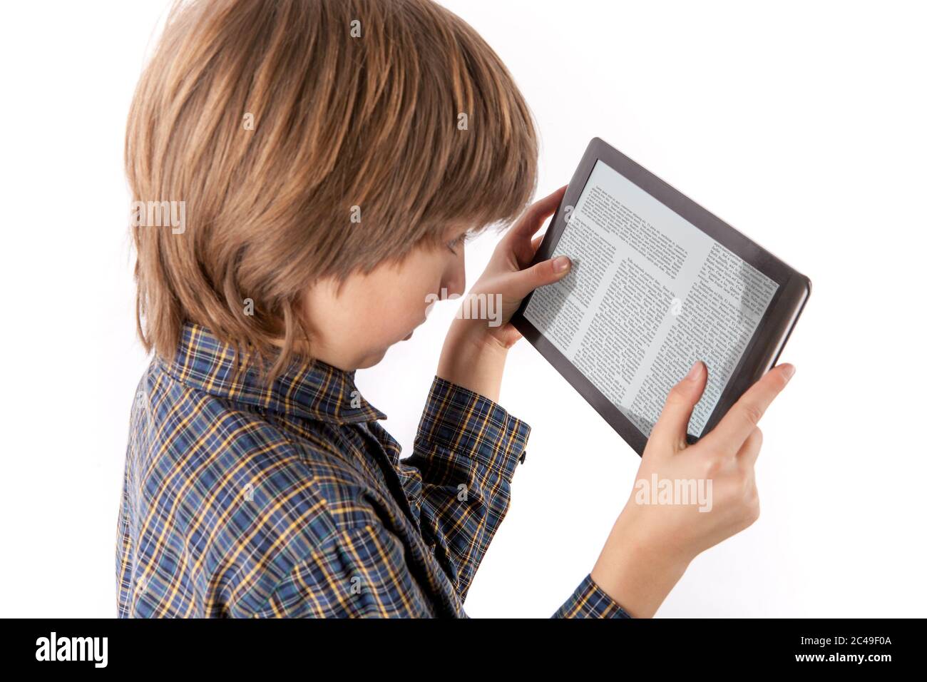 PC de table et autres gadgets peuvent causer des problèmes de vue - jeune garçon lisant un article sur une tablette la tenant trop près de ses yeux. Isolé sur le coup Banque D'Images