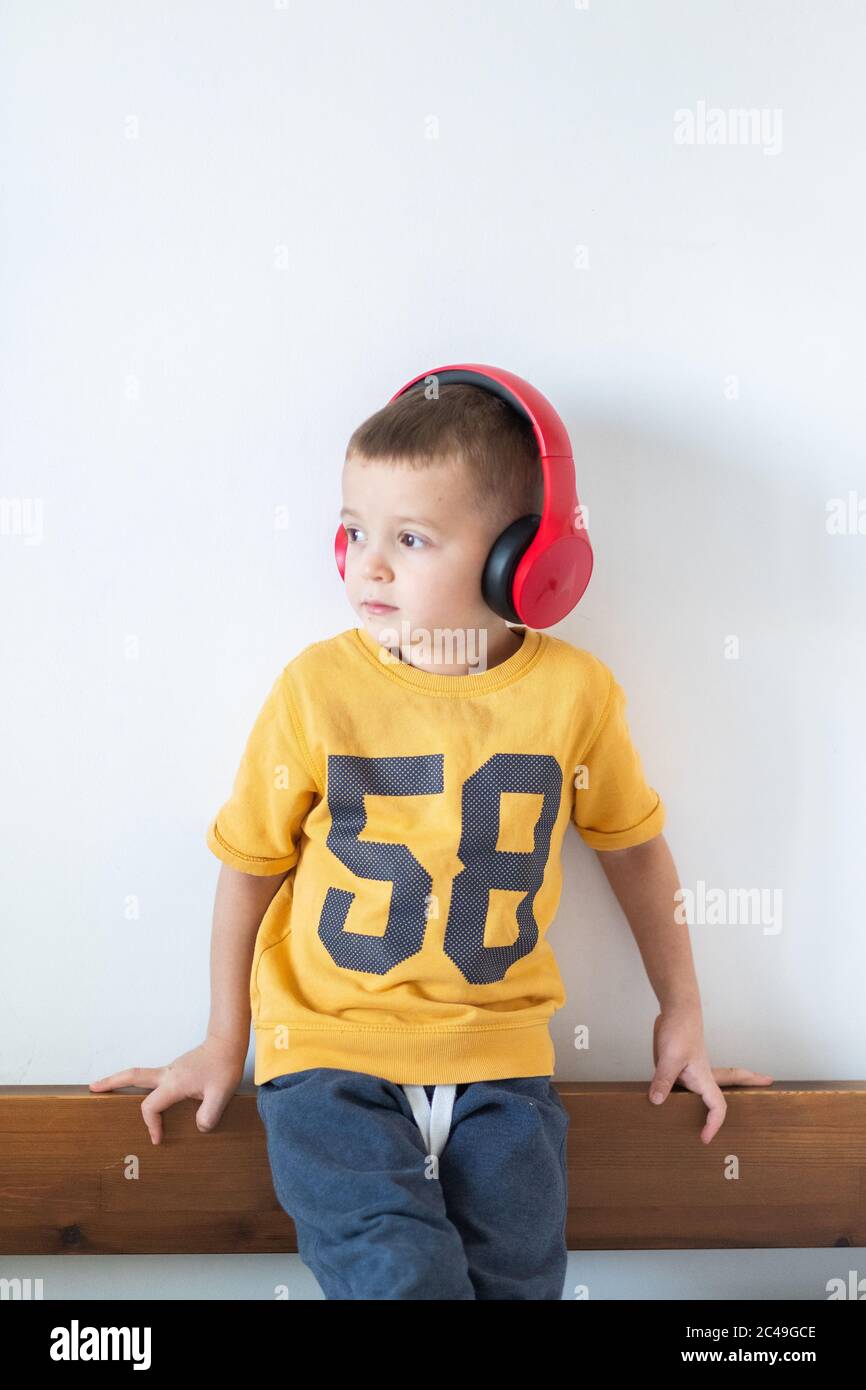 Garçon en t-shirt jaune avec casque isolé sur fond blanc Banque D'Images