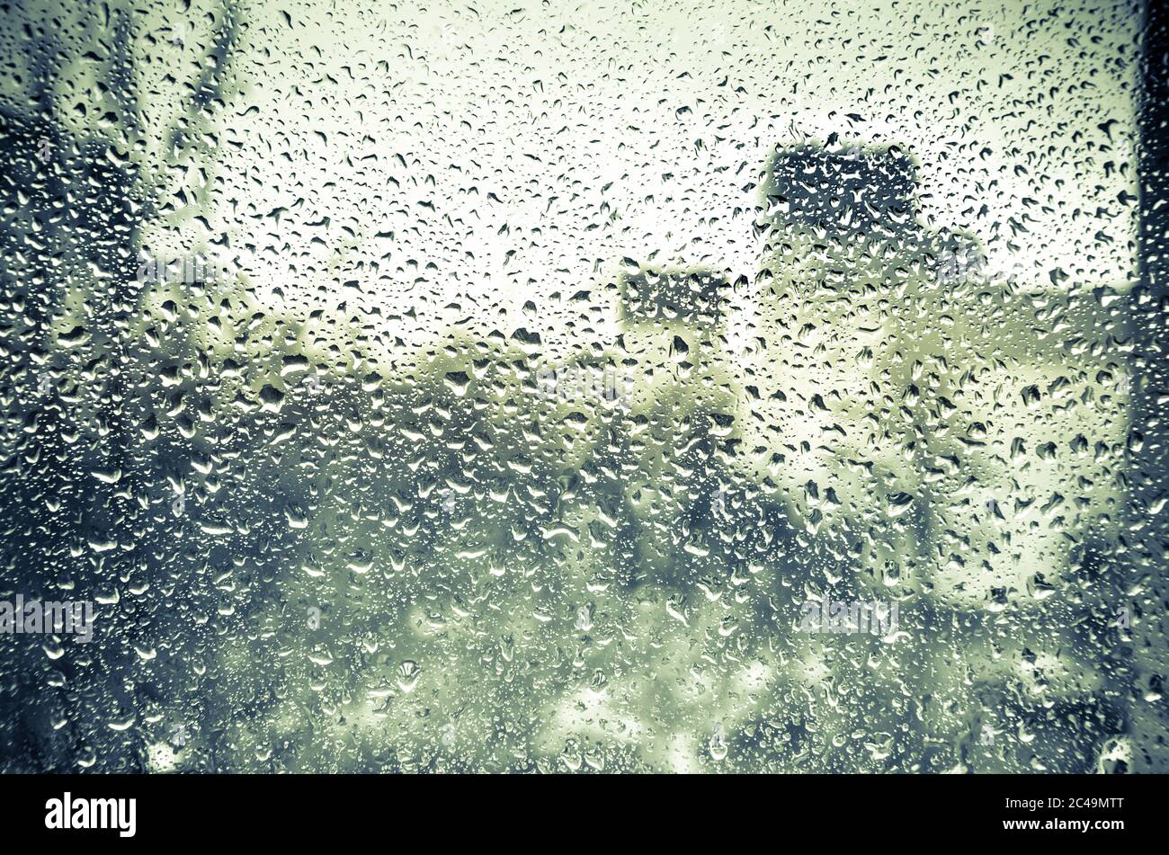 Vue floue sur la ville avec pluie par une fenêtre humide avec gouttes de pluie Banque D'Images