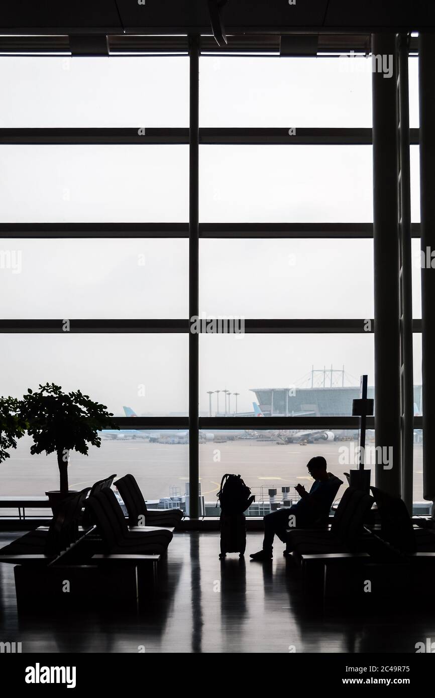 Incheon, Corée du Sud - aéroport international de Séoul Incheon. Silhouette d'un passager avec une valise en attente d'un vol dans la zone d'embarquement. Banque D'Images