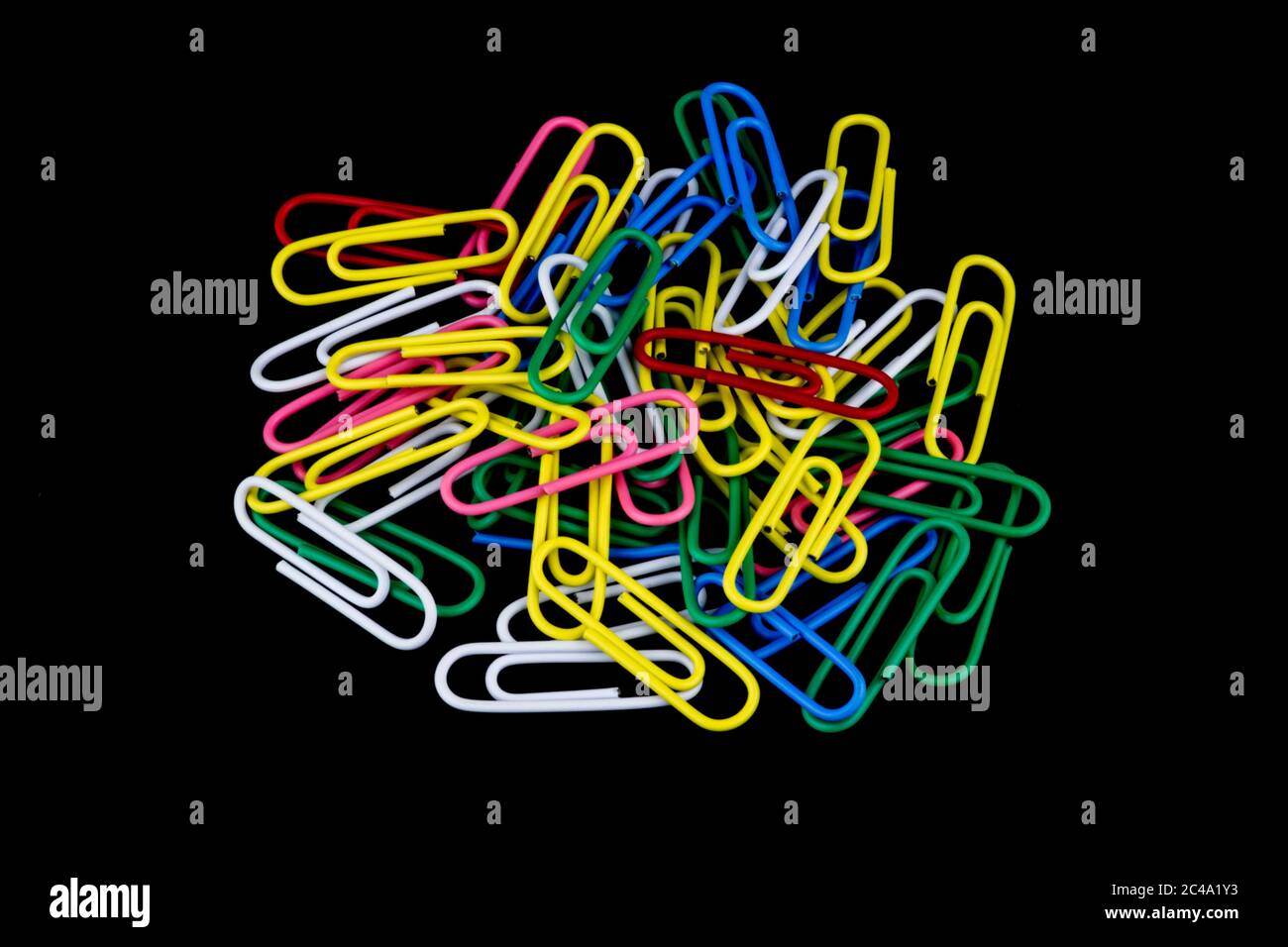 Pile de trombones colorés isolés sur un fond noir Banque D'Images