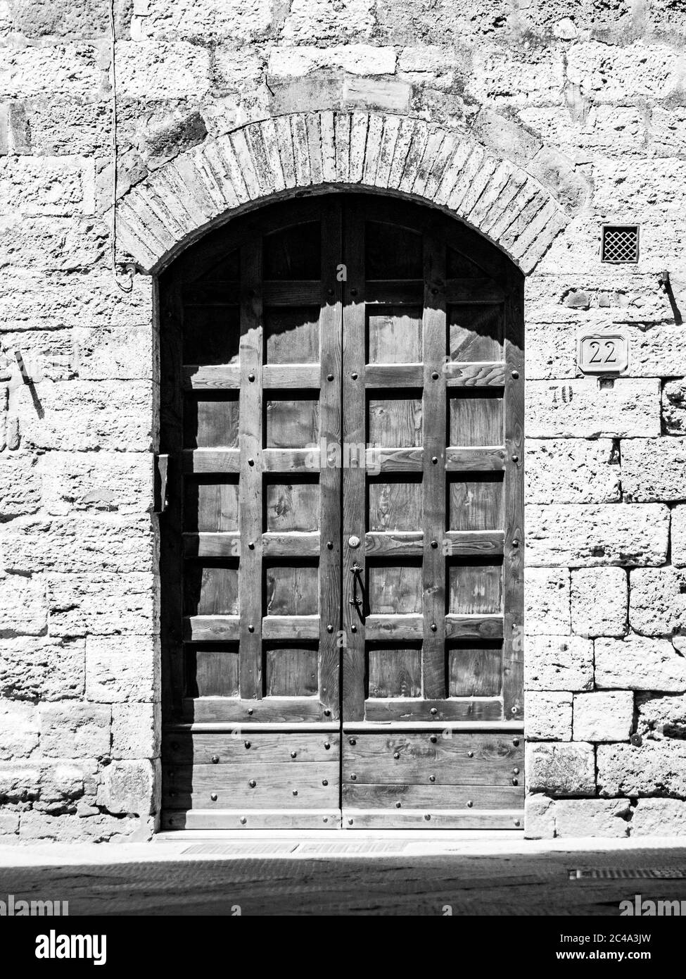 Ancienne porte en bois marron dans la rue médiévale. Image en noir et blanc. Banque D'Images