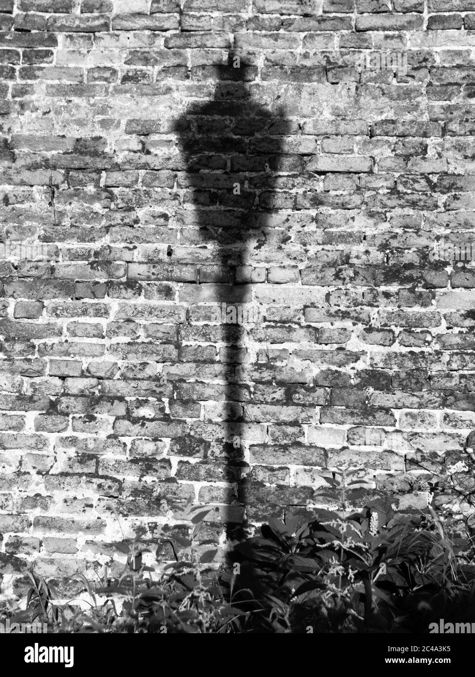 La lampe affiche l'ombre sur le mur de briques. Vieille ville de Prague, République tchèque. Image en noir et blanc. Banque D'Images