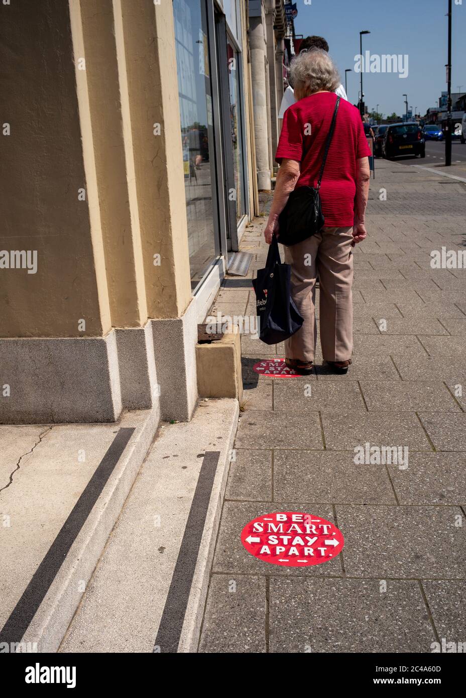 Signes sociaux de distanciation sur la chaussée pendant la pandémie du coronavirus à l'extérieur de la boutique de poste de Portswood Southampton. Soyez intelligent et gardez la distance. Banque D'Images