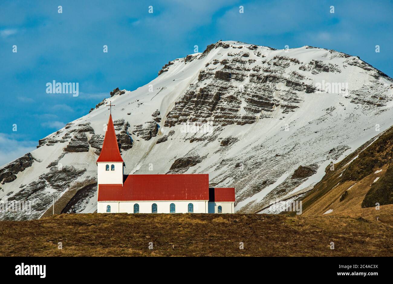 Église de Reyniscyrka au-dessus de la ville côtière de Vik, sur la côte sud de l'Islande, au large de la route côtière A1. Magnifiquement situé en face d'une montagne enneigée Banque D'Images