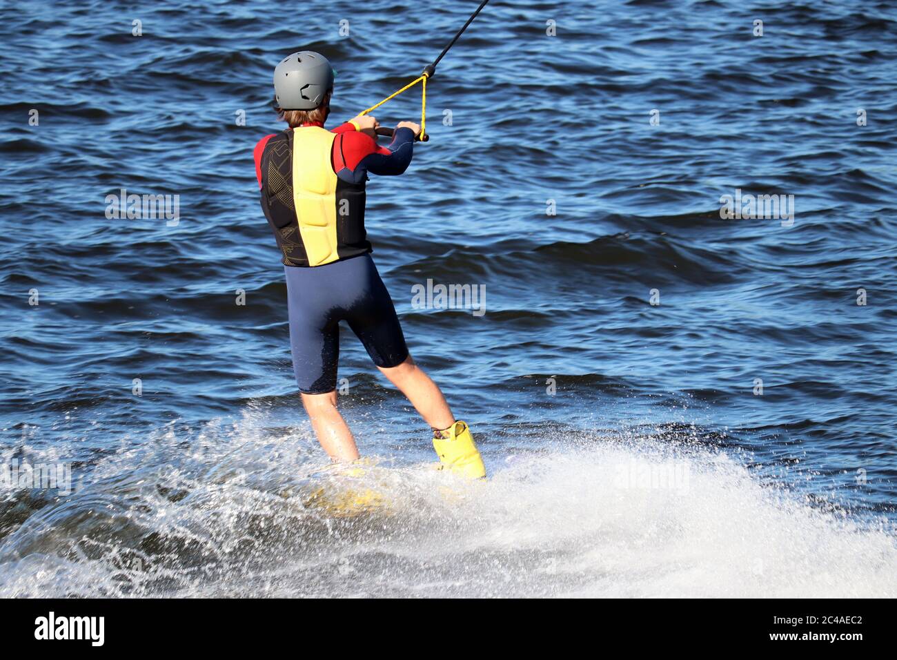 Wakeboard en journée ensoleillée, l'homme réalise un tour dans un jet d'eau. Surfez dans le parc wake, sports d'été Banque D'Images