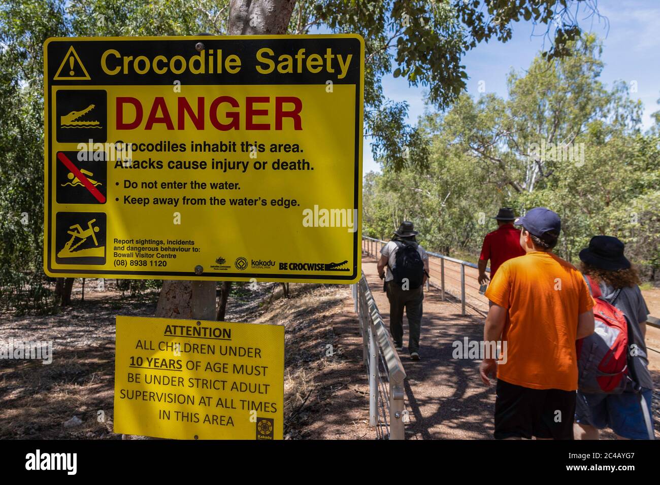 Parc national de Kakadu, Australie - 12 mars 2020 : les touristes marchant à côté d'un panneau d'avertissement de sécurité crocodile. Banque D'Images