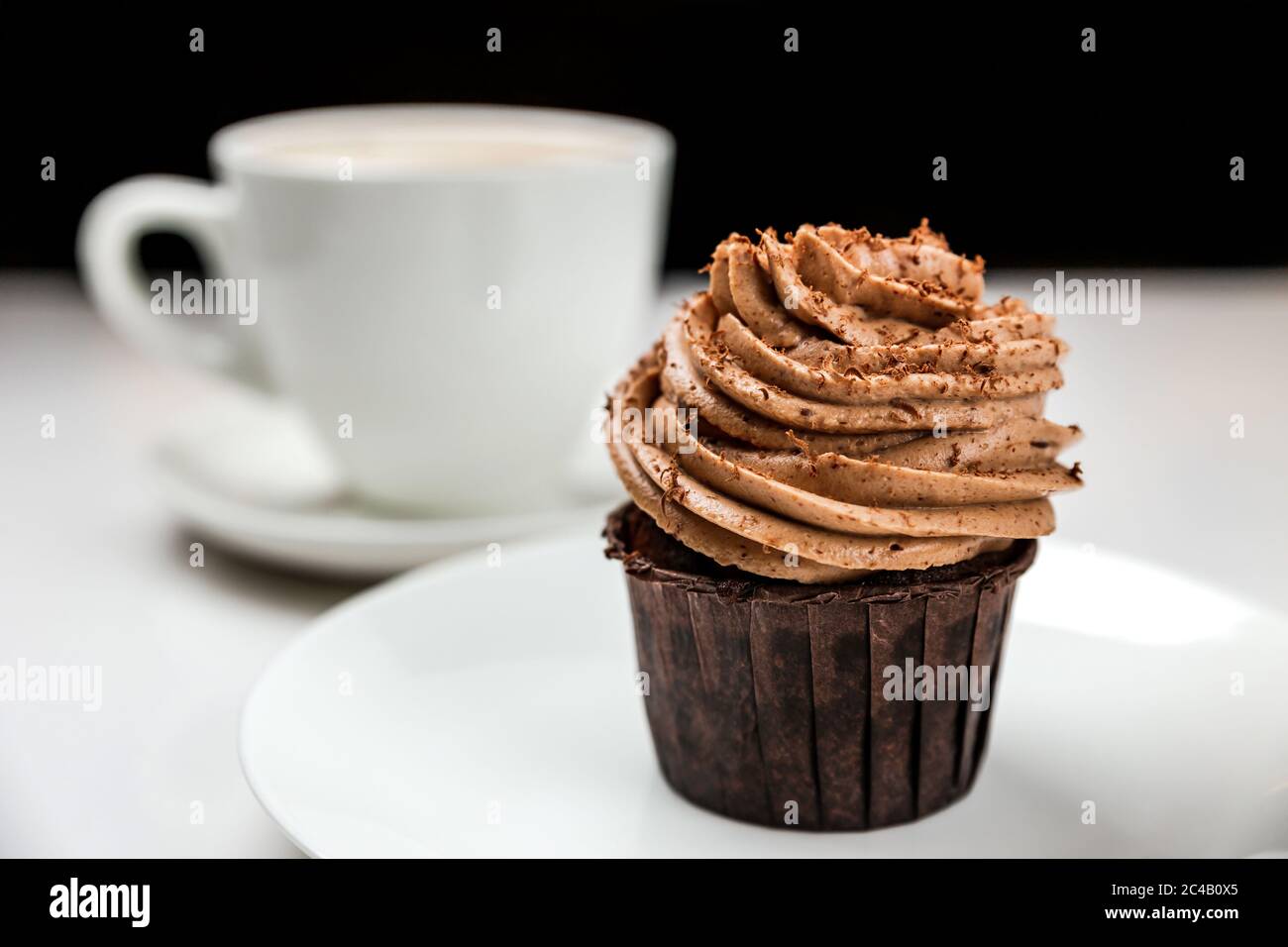 Un délicieux gâteau au chocolat avec de la crème et une tasse de cappuccino Banque D'Images