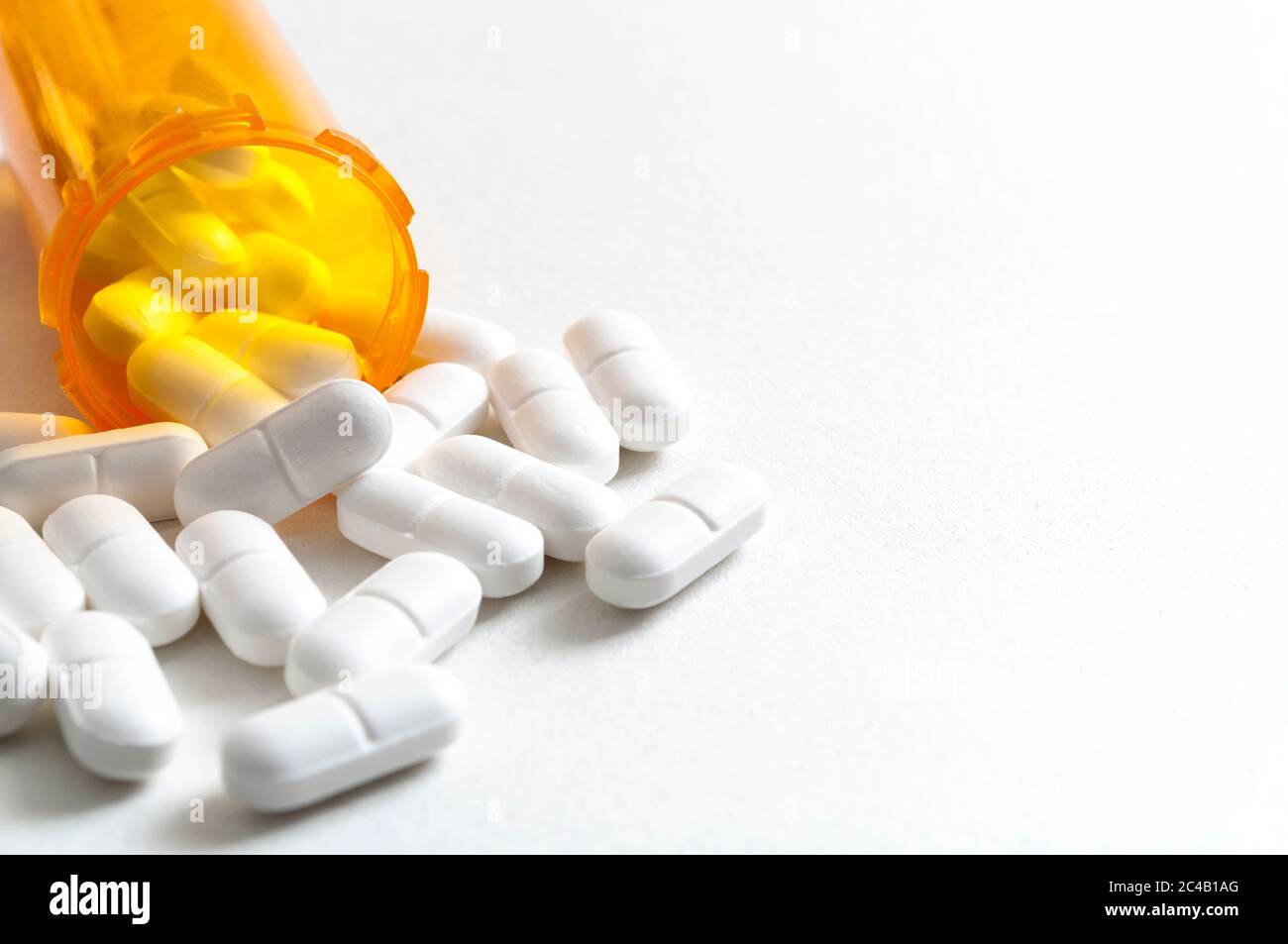 Épidémie d'opioïdes, abus de drogues et concept de surdose avec des opioïdes de prescription dispersés qui se répandent de la bouteille orange avec l'espace de copie. Hydrocodone est le g Banque D'Images