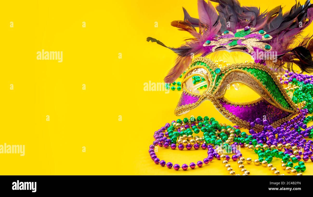 Happy Mardi gras et Mardi Carnival concept avec gros plan sur un masque de visage plein de couleur, plumes et texture et perles dorées, vertes et violettes Banque D'Images
