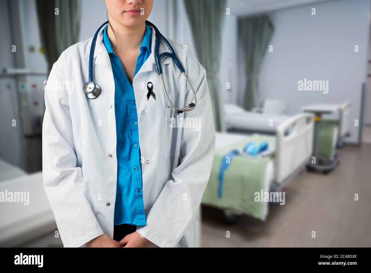 Section médiane de la femme médecin avec ruban noir debout sur la robe debout dans l'hôpital Banque D'Images