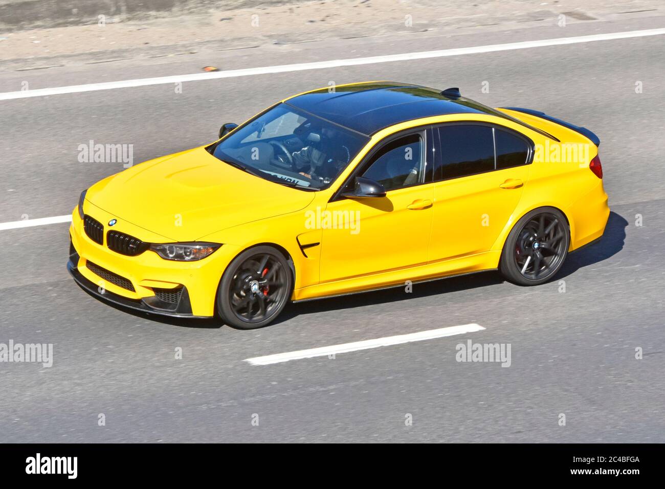 Vue latérale et avant du toit de l'antenne, quatre portes jaunes Voiture à moteur et conducteur BMW à toit noir Plaques commerciales sur la route autoroutière du Royaume-Uni Banque D'Images Vue latérale et avant du toit de l'antenne, quatre portes jaunes Voiture à moteur et conducteur BMW à toit noir Plaques commerciales sur la route autoroutière du Royaume-Uni Banque D'Images