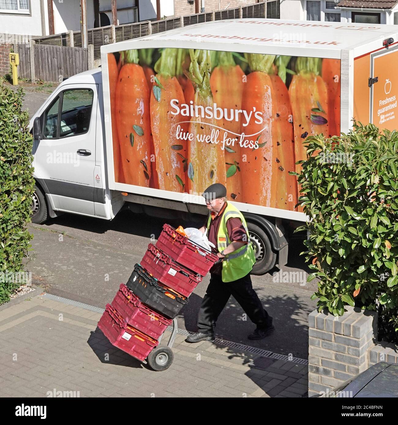 Sainsburys supermarché livraison de livraison de fourgon garée vue aérienne conducteur Wheeling nourriture dans des caisses de l'ordre en ligne de shopping d'Internet à la maison Essex Royaume-Uni Banque D'Images