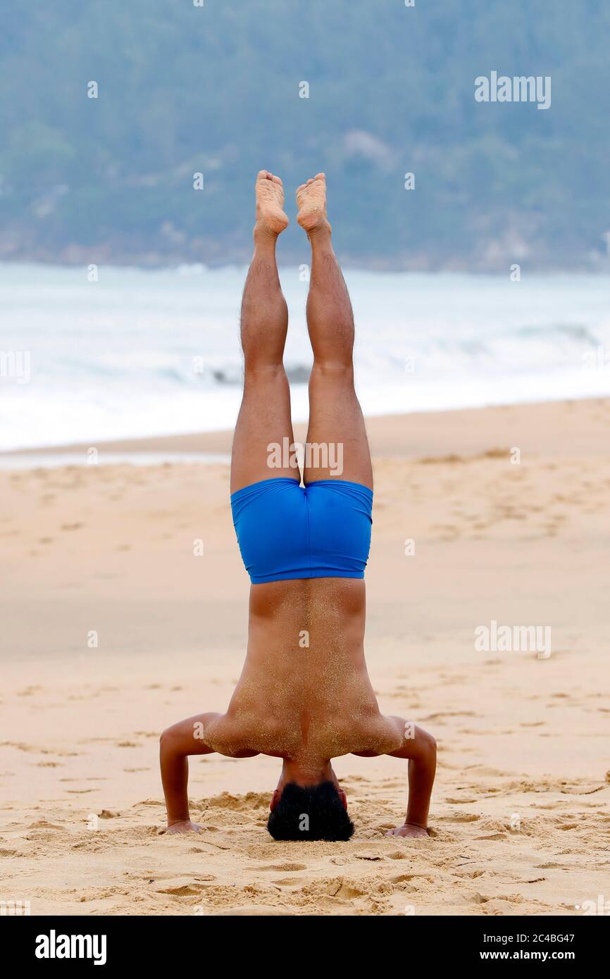 Homme faisant de la gymnastique matinale sur la plage Banque D'Images