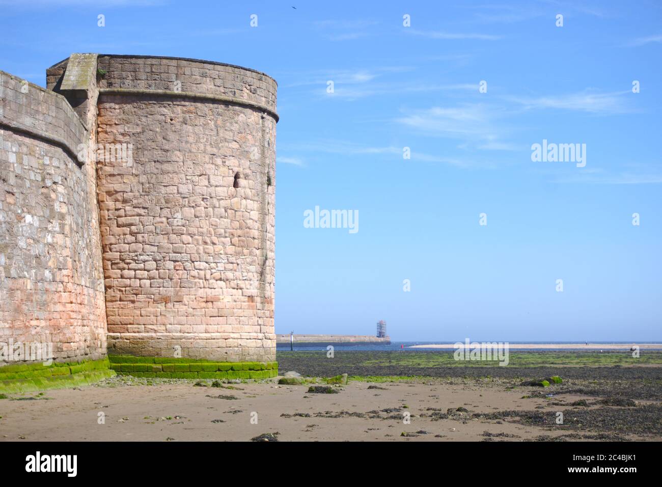 Tour Coxon médiévale qui regarde de l'autre côté de l'embouchure de la rivière Tweed vers la mer du Nord, avec le phare de Berwick au loin. Banque D'Images