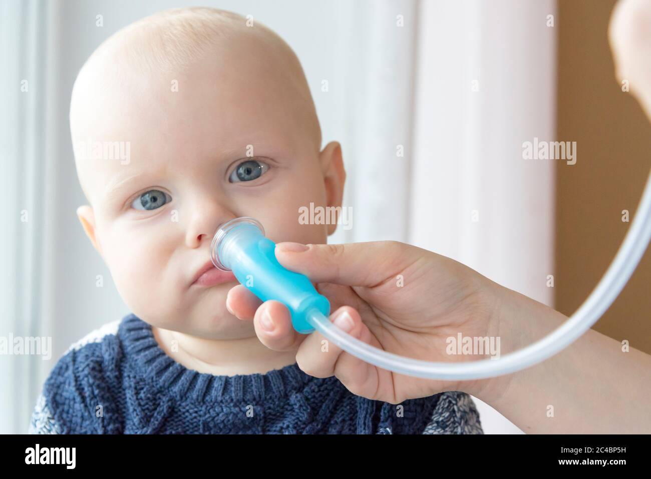 Maman nettoie le nez de bébé du mucus à l'aide d'un aspirateur nasal Photo  Stock - Alamy