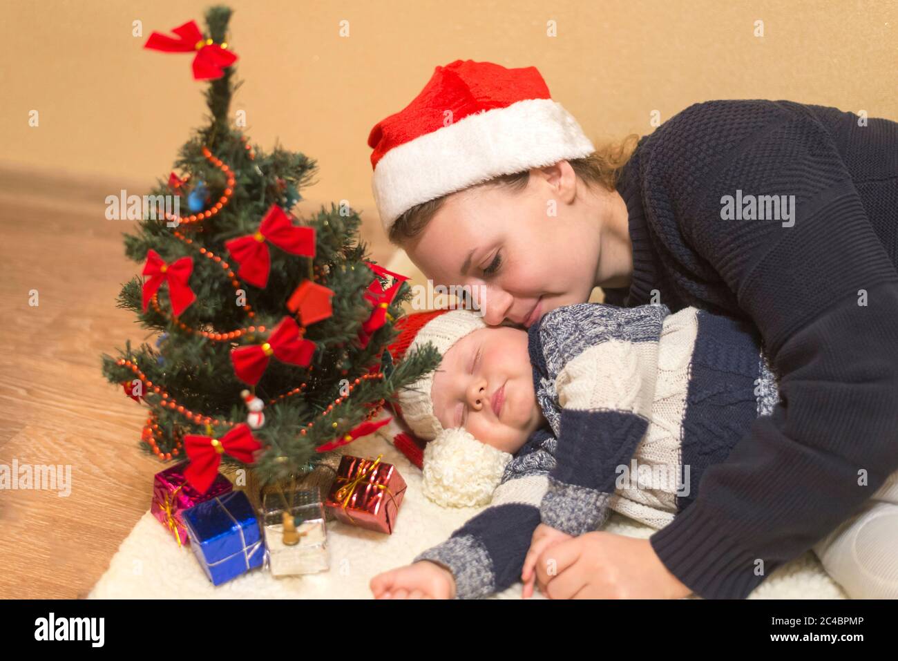 Maman câle son bébé endormi dans un chapeau de Père Noël Photo Stock - Alamy