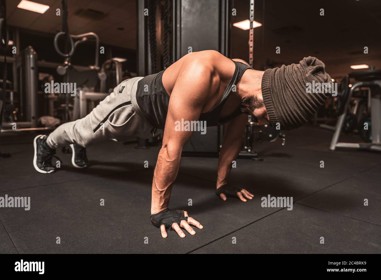 Un sportif dans la salle de gym fait des exercices de yoga, s'entraîner debout dans la posture de planche, faire des exercices de poussée ou de poussée vers le haut, l'entraînement, couvert pour le Banque D'Images