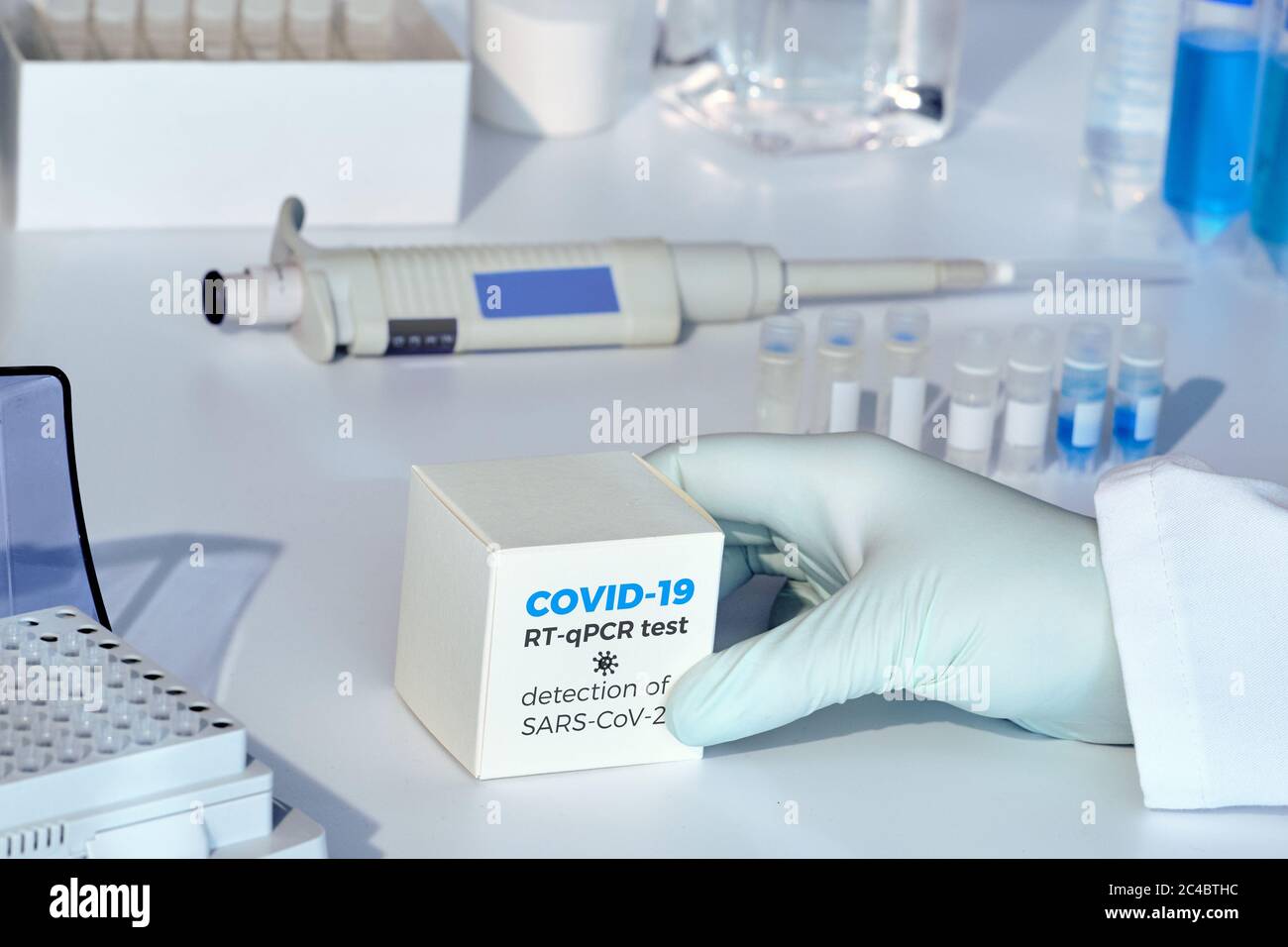 Kit de test de coronavirus COVID-19 de Quick Novel. Kit de diagnostic pcr SARS-CoV-2. Main dans le gant avec la boîte. Le kit détecte la maladie de covid19. Banque D'Images