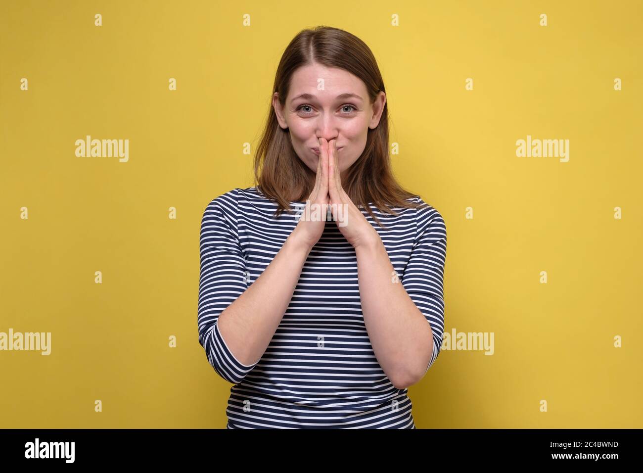 Heureux calme reconnaissant adolescente fille joindre les mains prier en remerciant en espérant croire, sourire. Banque D'Images