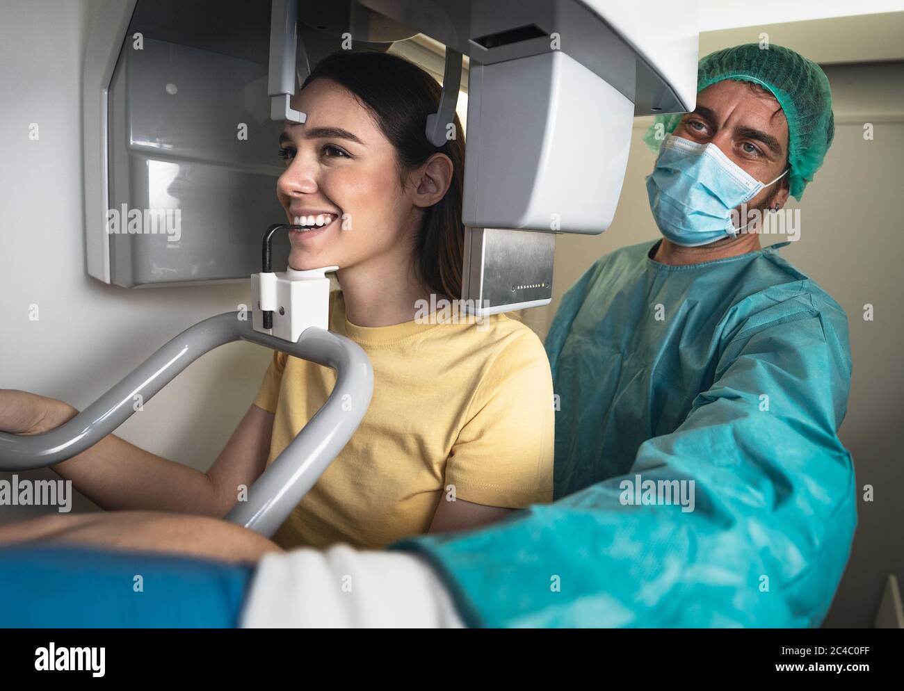 Jeune femme patiente debout dans une machine à rayons X - dentiste faisant la radiographie dentaire panoramique - concept de soins de santé Banque D'Images