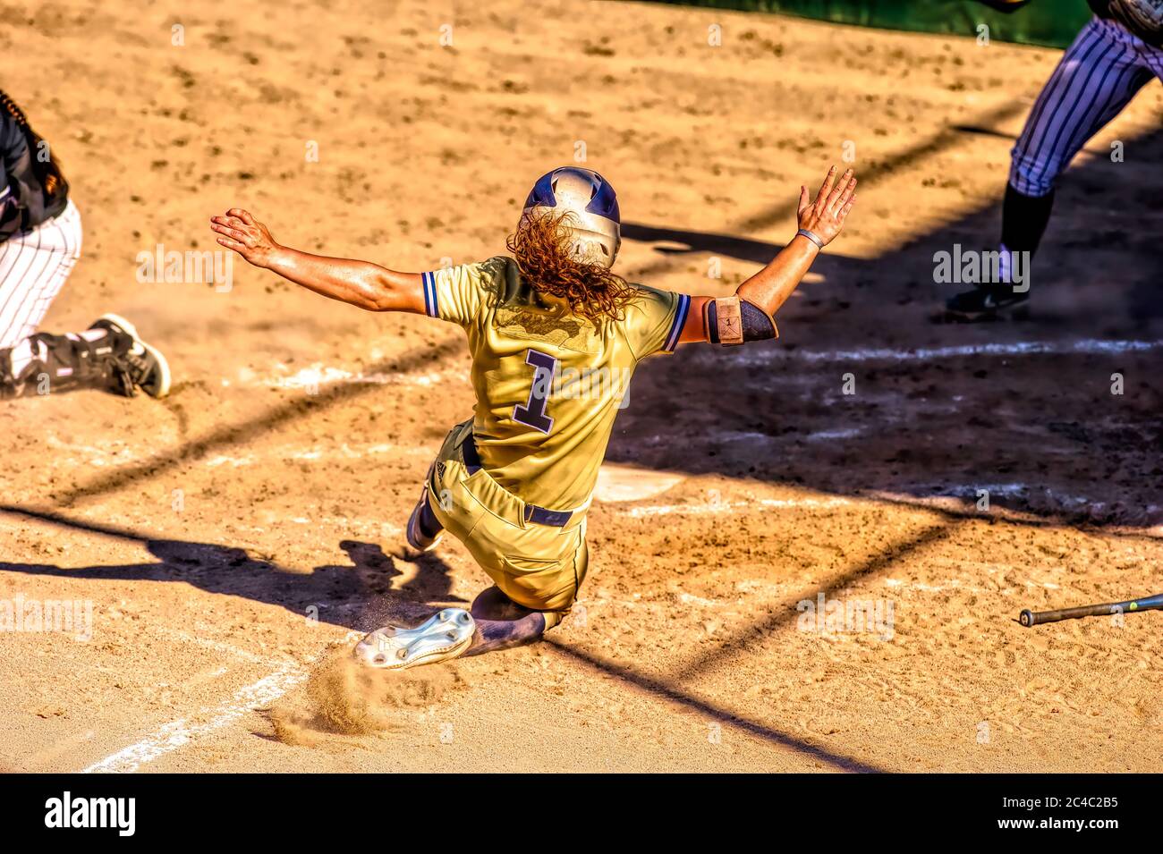 Un joueur de baseball glisse dans la plaque d'accueil Banque D'Images