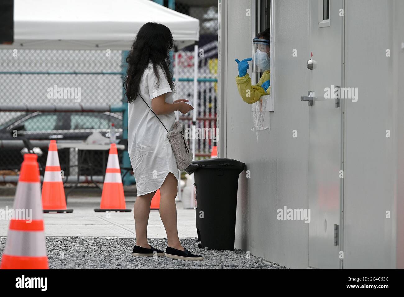 New York, États-Unis. 25 juin 2020. Une travailleuse médicale en EPI complet, demande comment elle va insérer un écouvillon dans le nez du patient pour administrer un test de coronavirus au SITE DE TEST DE BASE Covid-19, un site de test permanent dans le quartier Queens de New York City, NY, le 25 juin 2020. CORE (Community Organisation relief effort) est une organisation à but non lucratif fondée par l'acteur Sean Penn, qui a initialement créé l'organisation en réponse au tremblement de terre de janvier 2010 en Haïti. (Anthony Behar/Sipa USA) crédit: SIPA USA/Alay Live News Banque D'Images