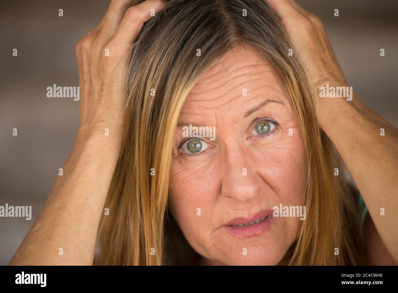 Portrait belle femme mature, stressée, anxieux, peur, expression malheureuse, mains couvrant la tête, arrière-plan flou. Banque D'Images
