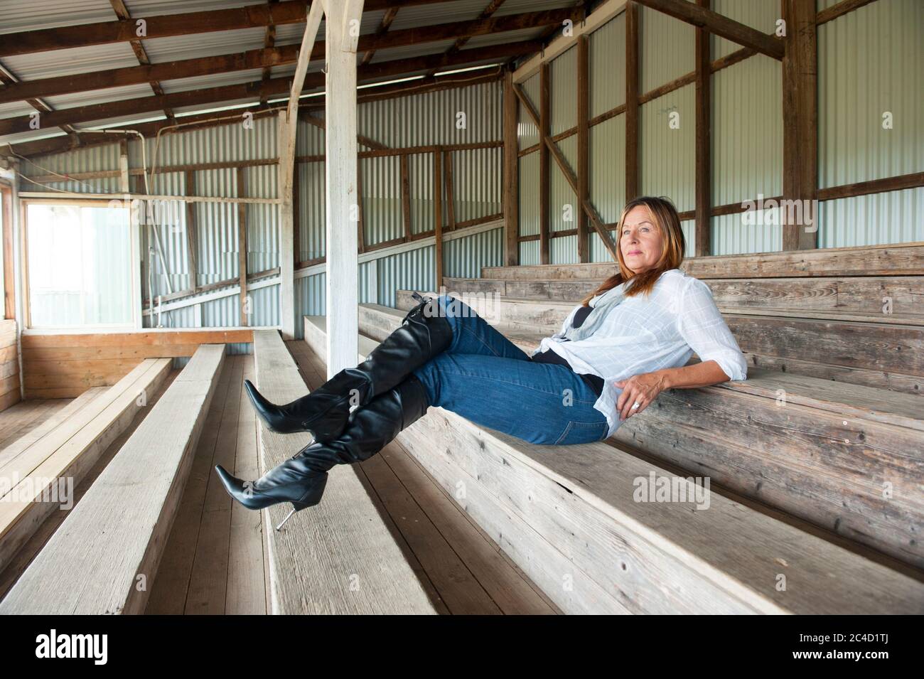 Portrait belle femme mature assise décontractée et confiante dans la grange  en bois, portant des jeans, talons hauts talons aiguilles bottes, espace de  copie Photo Stock - Alamy