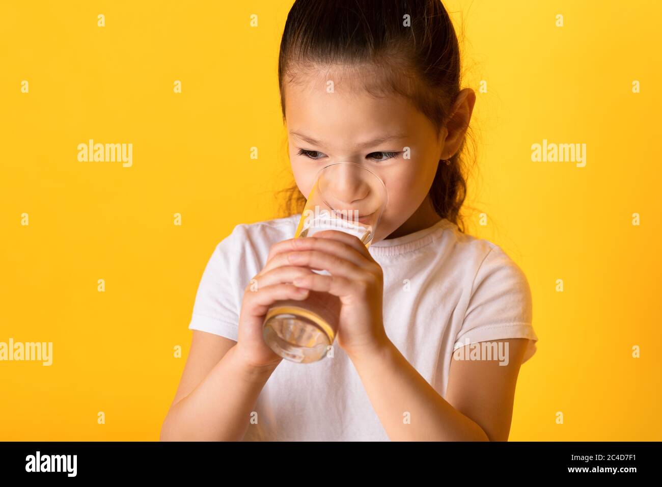 Portrait d'un enfant asiatique joyeux qui boit de l'eau douce Banque D'Images
