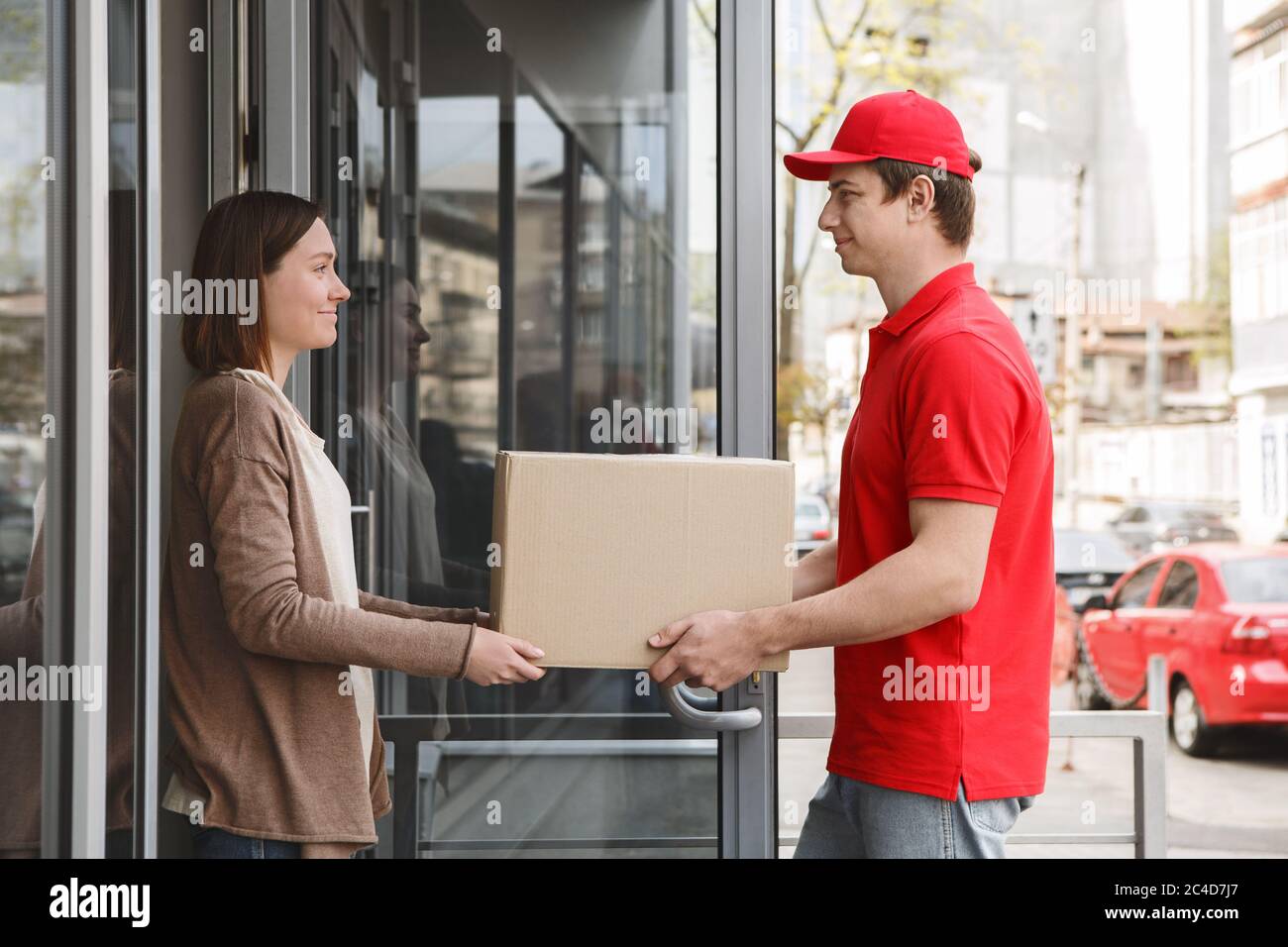 Service clientèle à domicile. Fille prend carton boîte de messagerie Banque D'Images