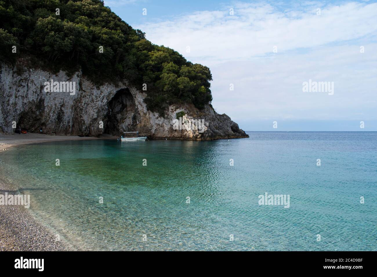 Bateau sur la mer dans une baie grecque à Corfù par temps nuageux Banque D'Images