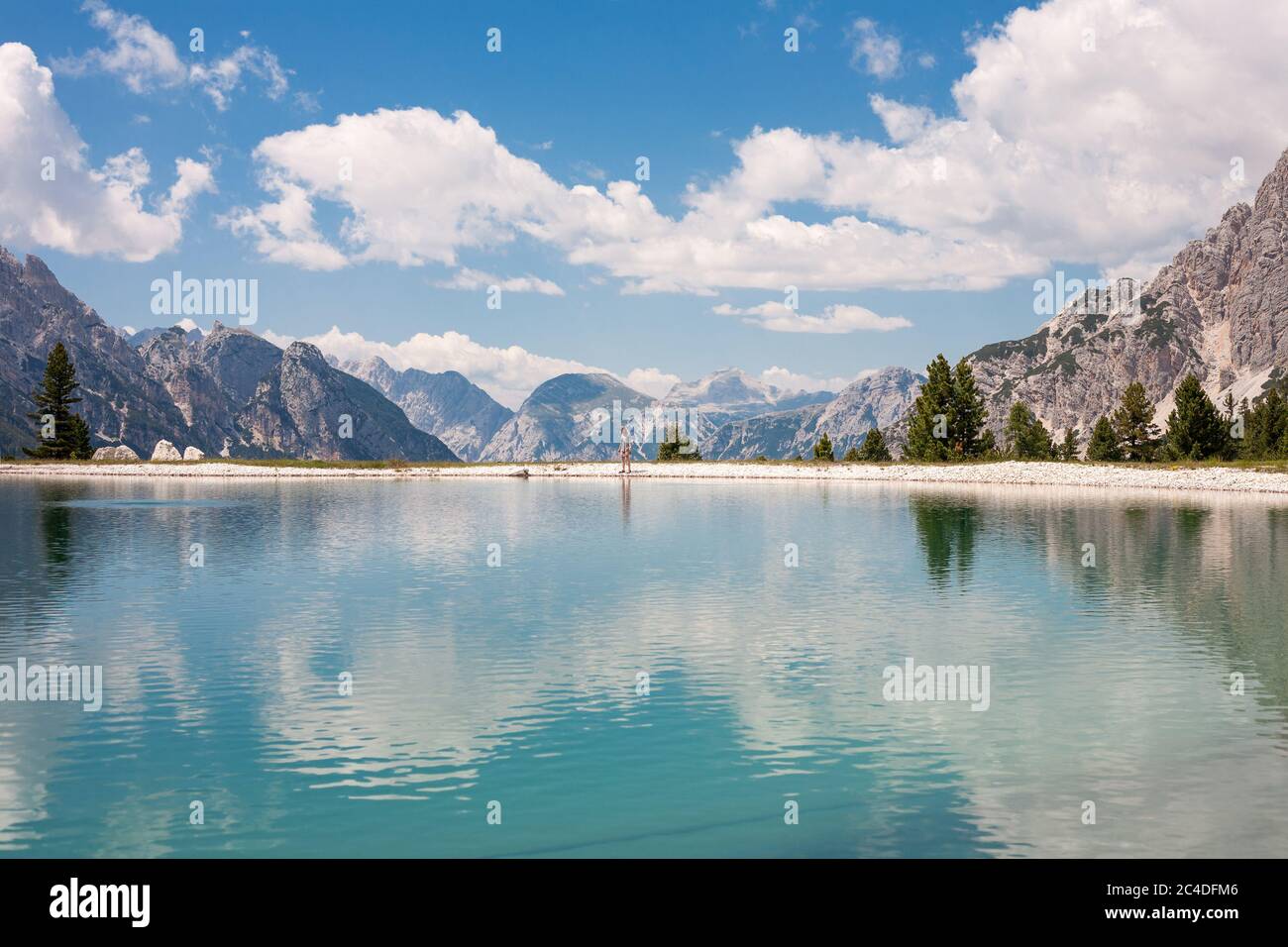 Jeune randonneur se trouvant sur la côte d'un lac turquoise près de tod Cresta Bianca (Cortina d'Ampezzo, Italie) Banque D'Images