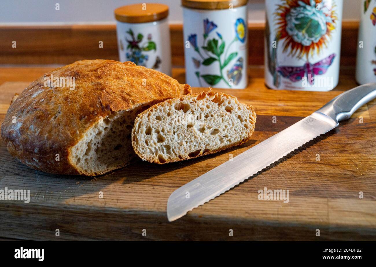 Pain de levain maison avec couteau à pain sur planche à découper photo prise par Simon Dack Banque D'Images