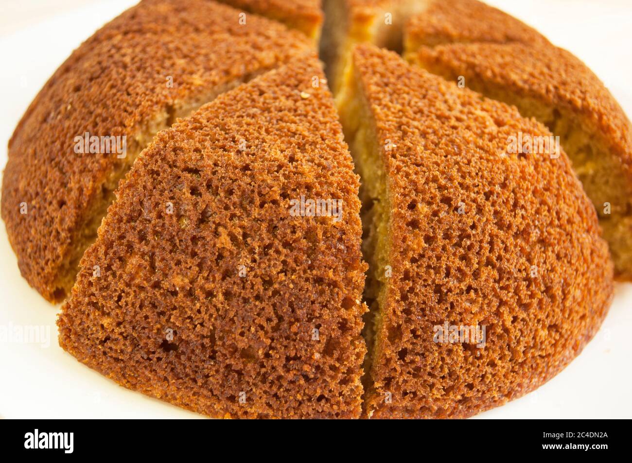 En tranches, on a divisé la tarte aux éponges en portions sur fond blanc. Aspect minimaliste. Banque D'Images