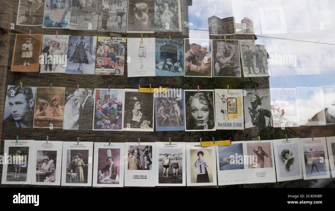 Photos suspendues dans une fenêtre de magasin avec des reflets en verre Banque D'Images