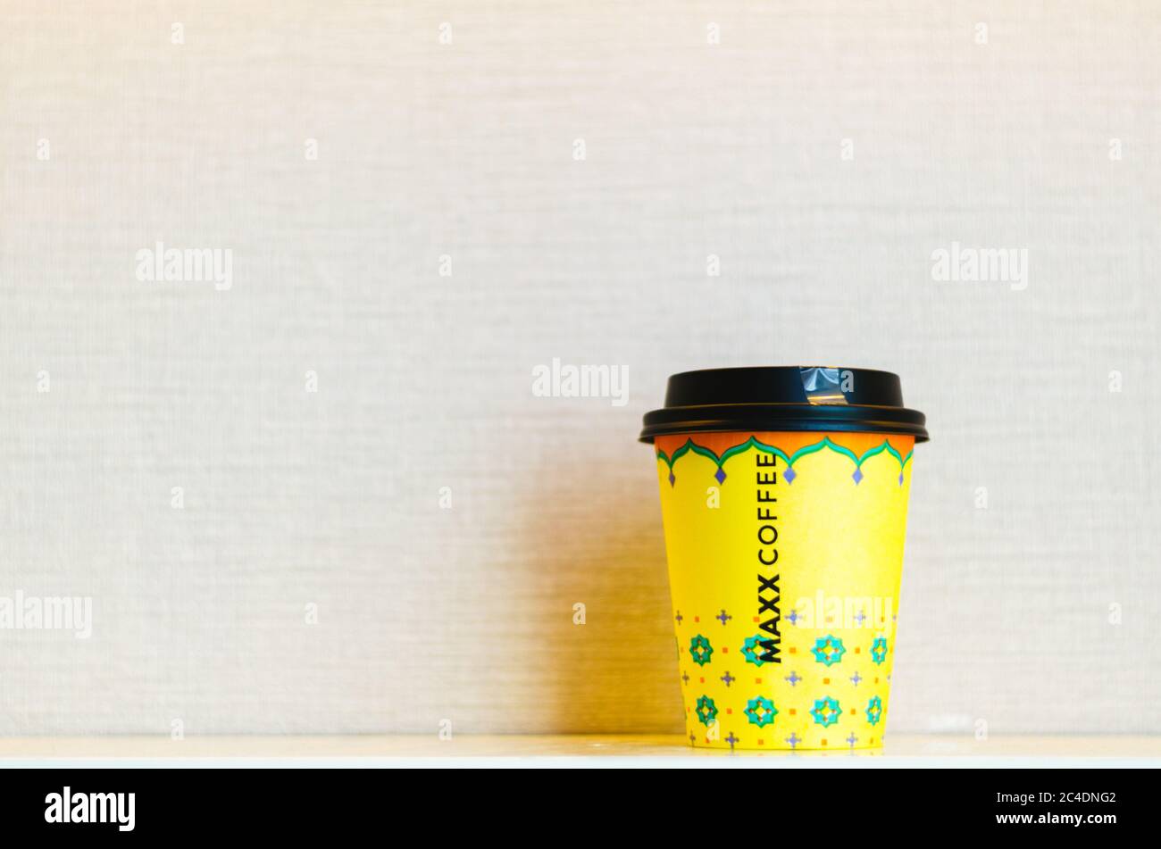 Une tasse de café à emporter jaune avec le nom de la chaîne de café Maxx inscrit au centre de la tasse. Banque D'Images