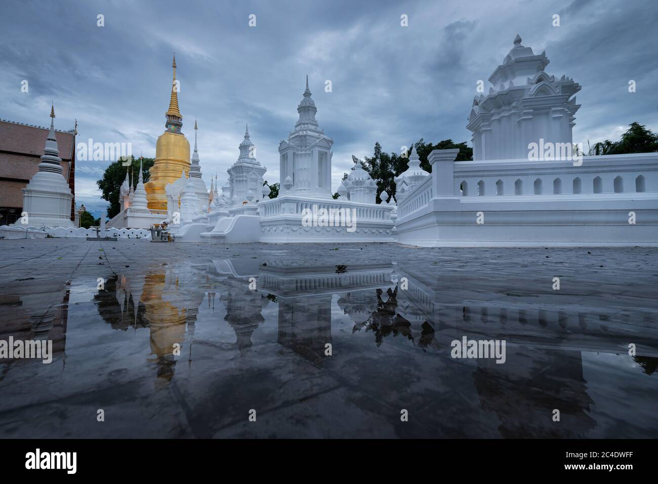 Réflexion du temple de la pagode dorée Suan Dok dans l'eau de raindrop sur le sol Banque D'Images