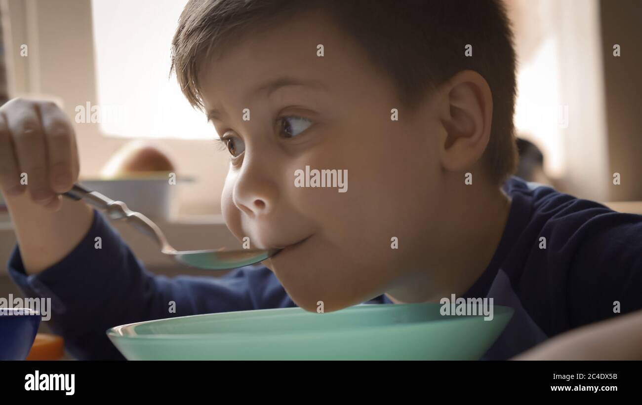 Un enfant affamé mange de la soupe. Petit garçon a le déjeuner ou le dîner à la maternelle. Gros plan Banque D'Images