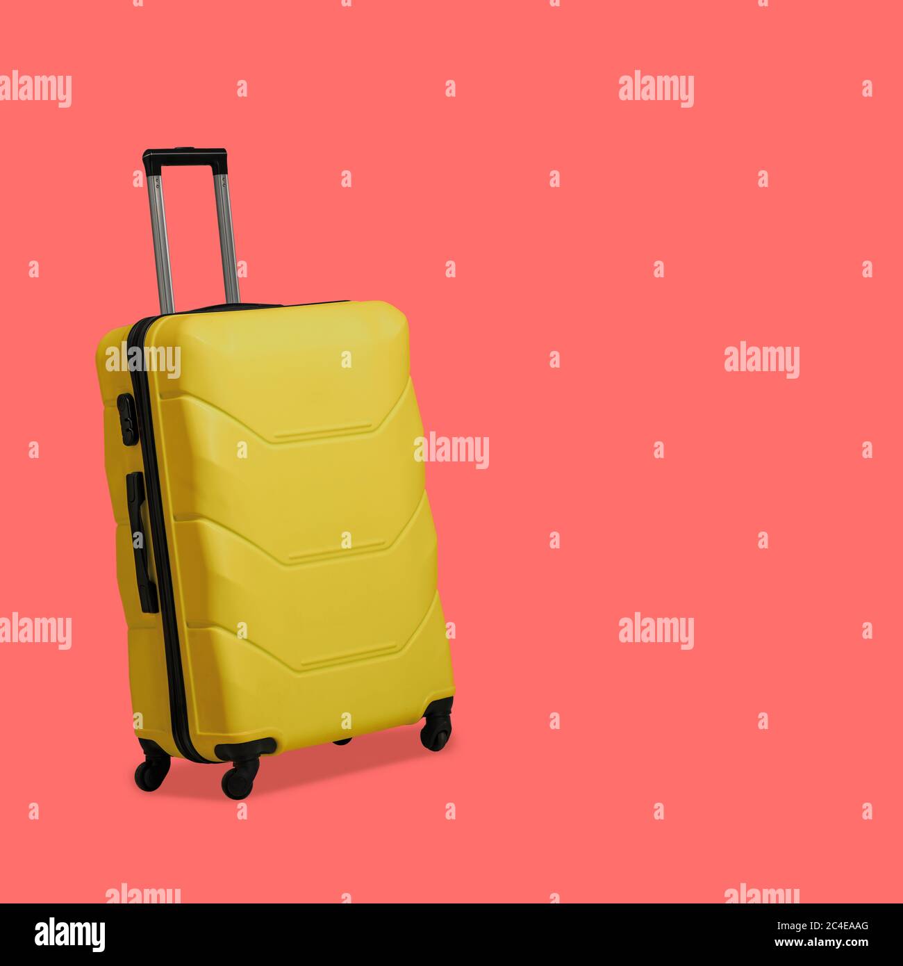 Valise jaune en plastique isolée sur fond rose. Valise avec roulettes et poignée télescopique rétractable. Concept de voyage. Modèle vide pour les réseaux sociaux Banque D'Images
