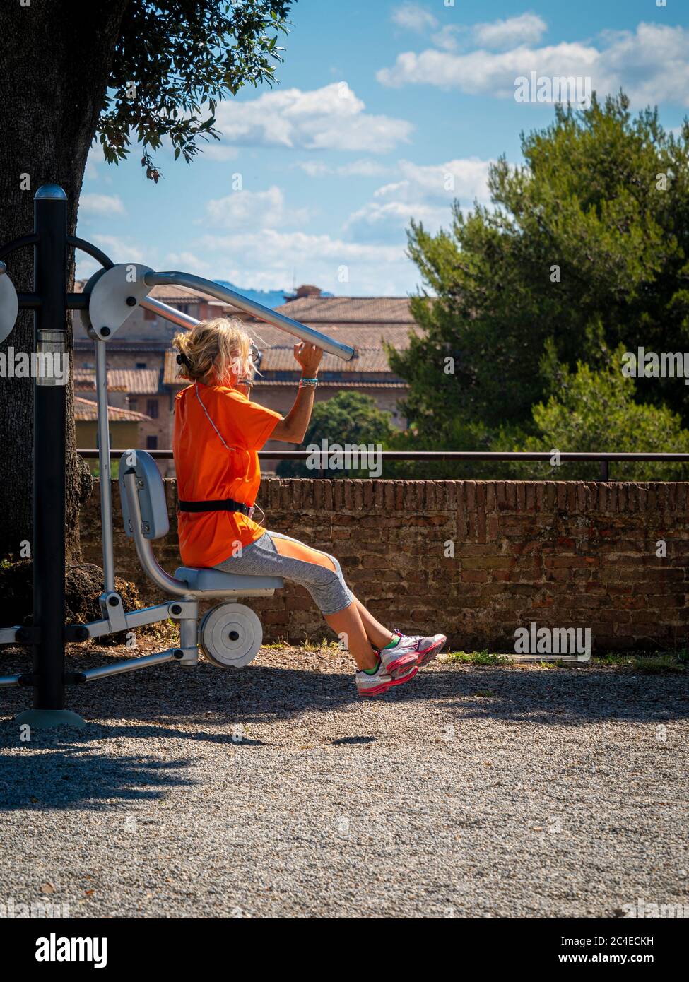 Femme utilisant l'équipement de gym dans la salle de gym extérieure a la forteresse Medici. Sienne. Italie. Banque D'Images