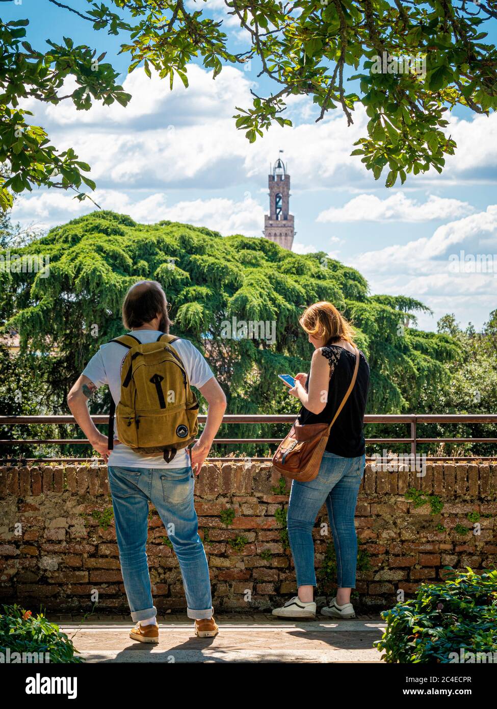 Touristes hommes et femmes à la recherche d'indications routières sur un téléphone portable. Sienne, Italie. Banque D'Images