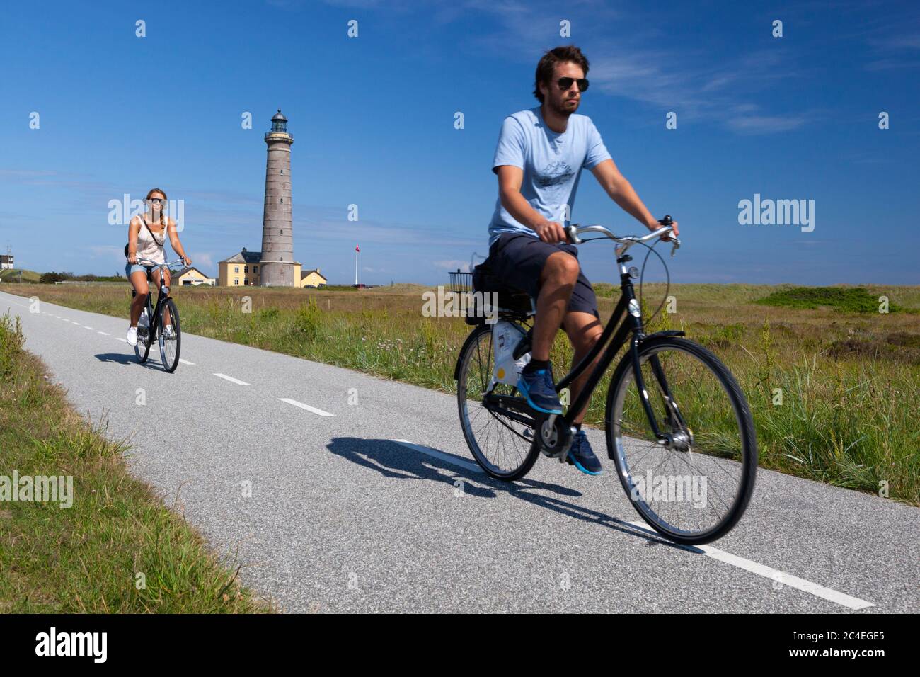 Cyclistes sur le sentier cyclable le long de Fyrvej avec Skagen FYR (phare) derrière, Skagen, Jutland, Danemark, Europe Banque D'Images